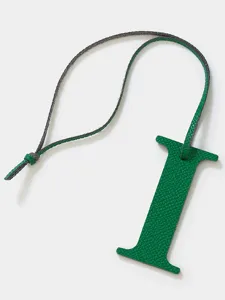 Detalle de colgante para bolso con letra I de cuero verde, accesorio elegante para llaves.