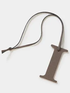 Detalle del colgante letra I de piel, elegante accesorio para bolso y llavero elegante.