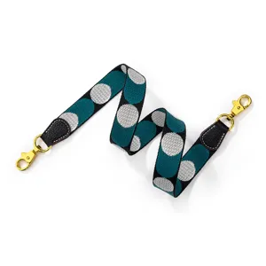 Stylish polka dot bag strap with gold hardware and leather ends for luxury handbags.