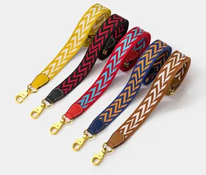 Colorful woven bag straps with chevron pattern and gold metal clasps for shoulder bags.