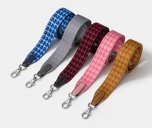 Detailed view of colorful houndstooth wide bag straps with metal hooks for crossbody bags.