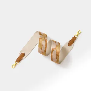 Stylish woven wide replacement bag strap with leather ends and gold hardware for crossbody bags.