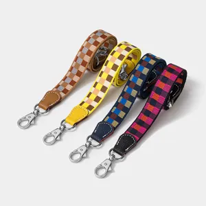 Tracolla di ricambio a quadri colorati con estremità in pelle e ganci metallici, borsa.