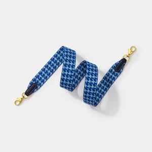 Blue houndstooth woven wide shoulder bag strap with gold clasps and leather ends for crossbody.