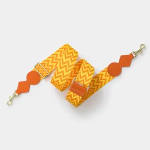 Detailed view of the orange and yellow zig-zag adjustable replacement bag strap.
