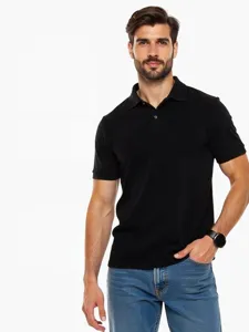 Close-up detail of a men's black short-sleeve polo shirt worn by a model in studio style.