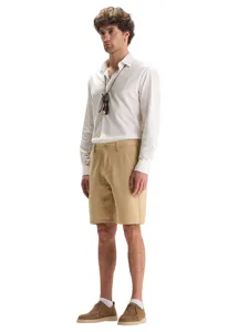 Vue détaillée de shorts kaki décontractés pour hommes avec chemise blanche et chaussures.