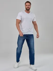 Jeans da uomo casual a gamba dritta abbinati a una classica t-shirt bianca per l'uso quotidiano.