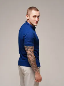 Detail shot of the men's short sleeve polo shirt showing fabric texture and fit from side view.