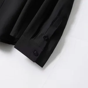 Black long sleeve shirt cuff detail close-up showing fine stitching and classic buttons.