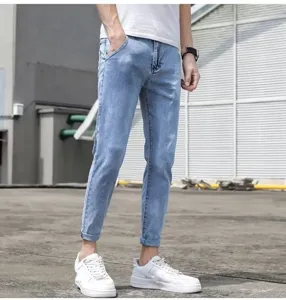 Detailed shot of men's light blue casual cropped jeans, slim fit denim pants for summer.