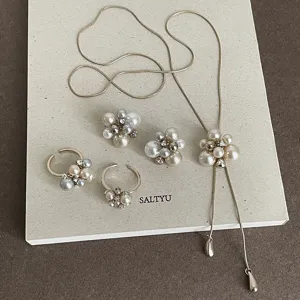 Close-up detail of the elegant pearl and crystal cluster jewelry set in champagne gold finish.