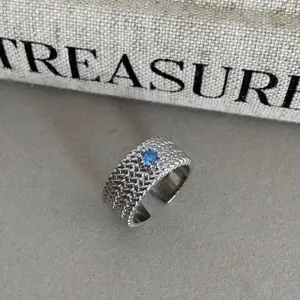 Bague argentée ouverte large avec pierre bleue, bijou tendance au design de niche.