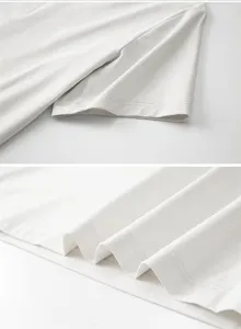 Dettaglio di t-shirt bianca tinta unita che mostra cuciture fini e tessuti di alta qualita.