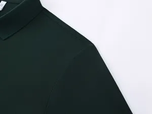 Dark green polo shirt collar and shoulder stitching detail showing fine craftsmanship and fabric.