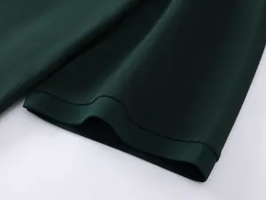 Close-up detail shot of dark green knit fabric and ribbed cuff, showing premium texture.