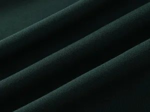 Close-up detail of dark green cotton fabric showing breathable weave texture and soft fabric.