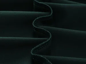 Close-up view of dark green fabric highlighting fine stitching and smooth texture detail.
