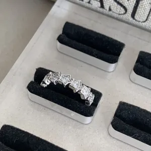 Gros plan détaillé d'une bague étoile argentée élégante avec des pierres scintillantes.