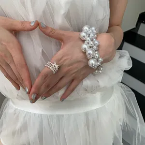 Detailed shot of a niche design multi-layer pearl wide ring with sparkly bowknot accent.