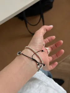Detail view of minimalist crystal bead and silver bracelet set worn on wrist, elegant style.