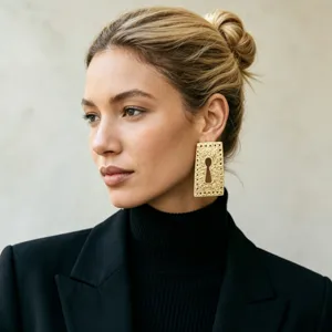 Close-up detail shot of vintage gold-toned textured rectangular keyhole statement earrings.