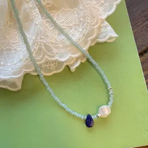 Détail de collier de perles vert menthe rétro français avec pendentif perle et lapis.