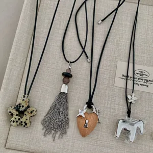 Quattro collane estetiche uniche con pietra, nappa, cuore di legno e cavallo di metallo.