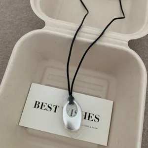 Collana con ciondolo ovale in metallo argentato minimalista con cordino nero gioiello chic