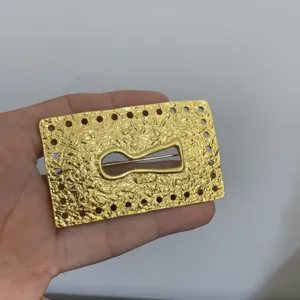 Gold tone textured metal keyhole design detail shot showcasing intricate surrealist brooch.