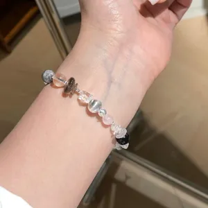Gedetailleerd overzicht van een onregelmatige natuurstenen kralenarmband met kristallen.