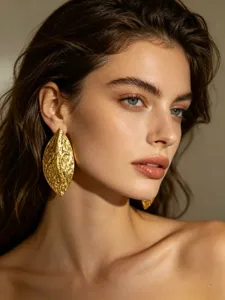 Gedetailleerde close-up van opvallende gouden oorbellen met een onregelmatige textuur afwerking.