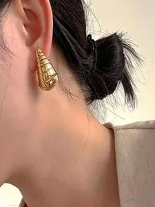 Gouden metalen schelpvormige oorknopjes voor dames, uniek geometrisch ontwerp detail.
