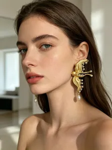 Exclusieve gouden vogel oorclip met sprankelende strass-steentjes en elegante parels voor dames.
