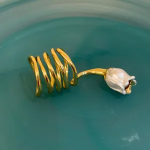 Gros plan détaillé de la bague tulipe perle spirale dorée avec texture coquillage et design ouvert.