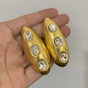 Close-up detail van luxe gouden druppeloorringen ingelegd met sprankelende heldere kristallen.