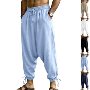 Detail shot of men's loose linen drop crotch harem joggers with drawstring casual beach pants.