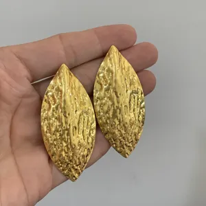 Gouden gestructureerde navette oorbellen, opvallende metalen hangende oorbellen trend.