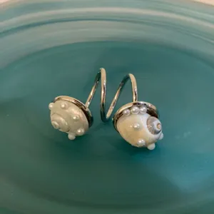 Vue détaillée de la bague ouverte élégante en coquillage et perles pour les vacances.