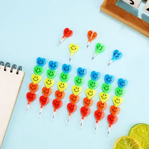Detail view of colorful stackable smiley heart pencils arranged neatly on clean light blue backdrop.