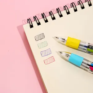Close-up detail shot of multi-color retractable ballpoint pens writing swatches on notebook.