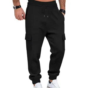 Vista detallada de los pantalones cargo negros para hombre con textura a cuadros y bolsillos útiles.