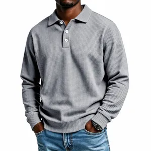 Detail view of a solid color waffle knit long sleeve polo shirt for men with lapel and buttons.