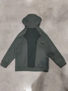 Back view detail of the dark green and black colorblock hoodie, showing stitching and hood.