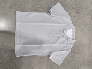 Vista detallada del polo de manga corta de punto gofrado gris con cuello cubano clásico.