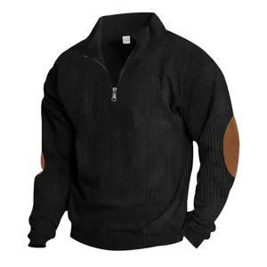 Detailed view of black half-zip sweater with brown elbow patches and collar tag.