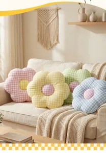 Detailed view of cozy checkered flower plush pillows on sofa, cute home decor aesthetic cushion.