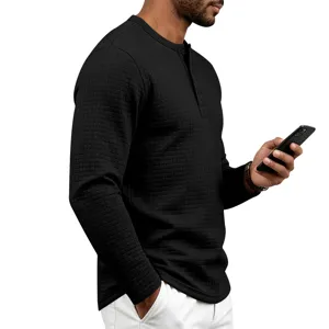 Gros plan sur le détail du t-shirt à manches longues texturé noir et boutons henley.