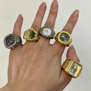 Primo piano di orologi ad anello in lega creativi indossati sulla mano con vari quadranti geometrici.