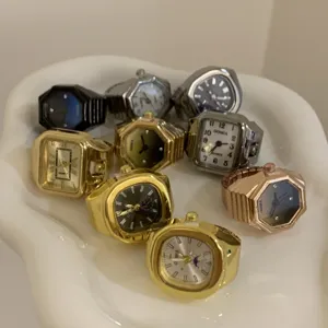 Dettaglio della vista dell'orologio ad anello in lega con diverse forme e colori geometrici.